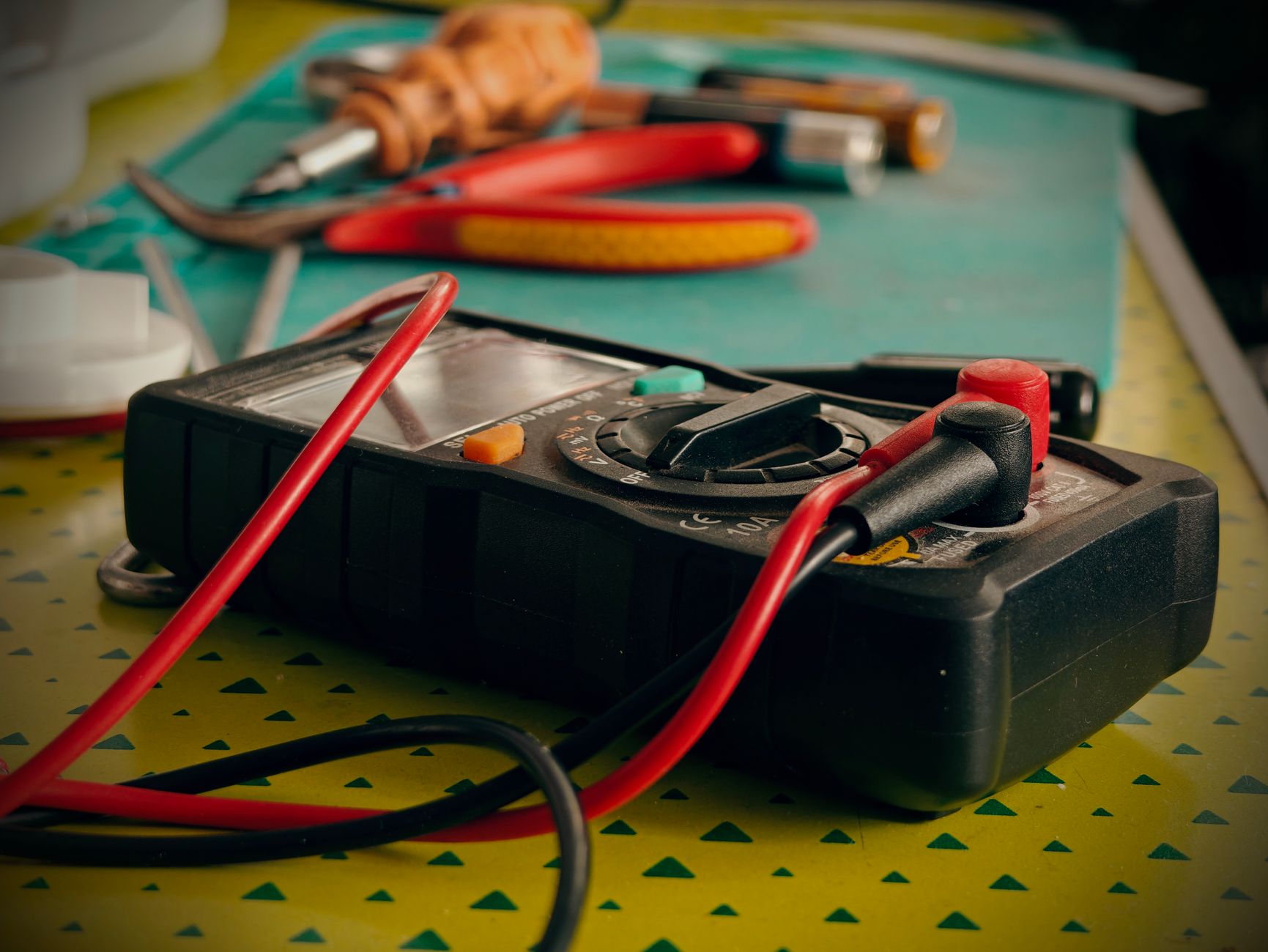 a close-up of a compact waveguide optical element laid flat on a laboratory workbench surrounded by precision measurement tools
