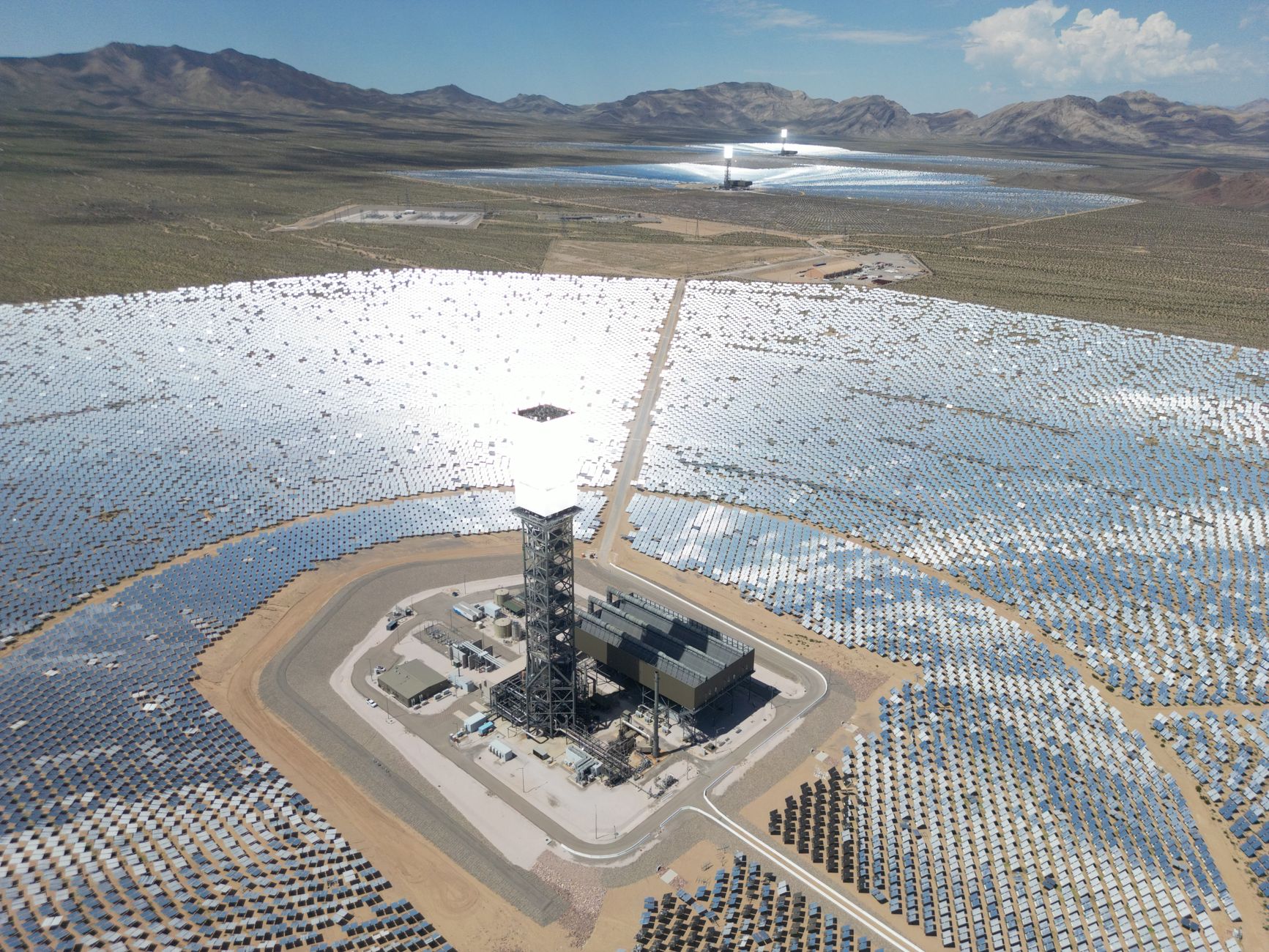 aerial view of a military technology testing facility with radar arrays and communications equipment mounted across a wide open field