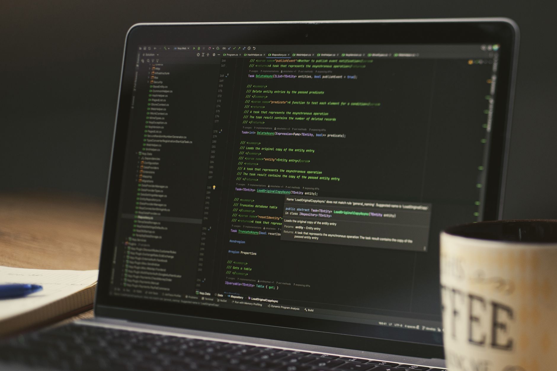 a laptop screen displaying a grid of blurred image thumbnails in a dark-mode interface, with a terminal window overlaid showing lines of encoded URL strings