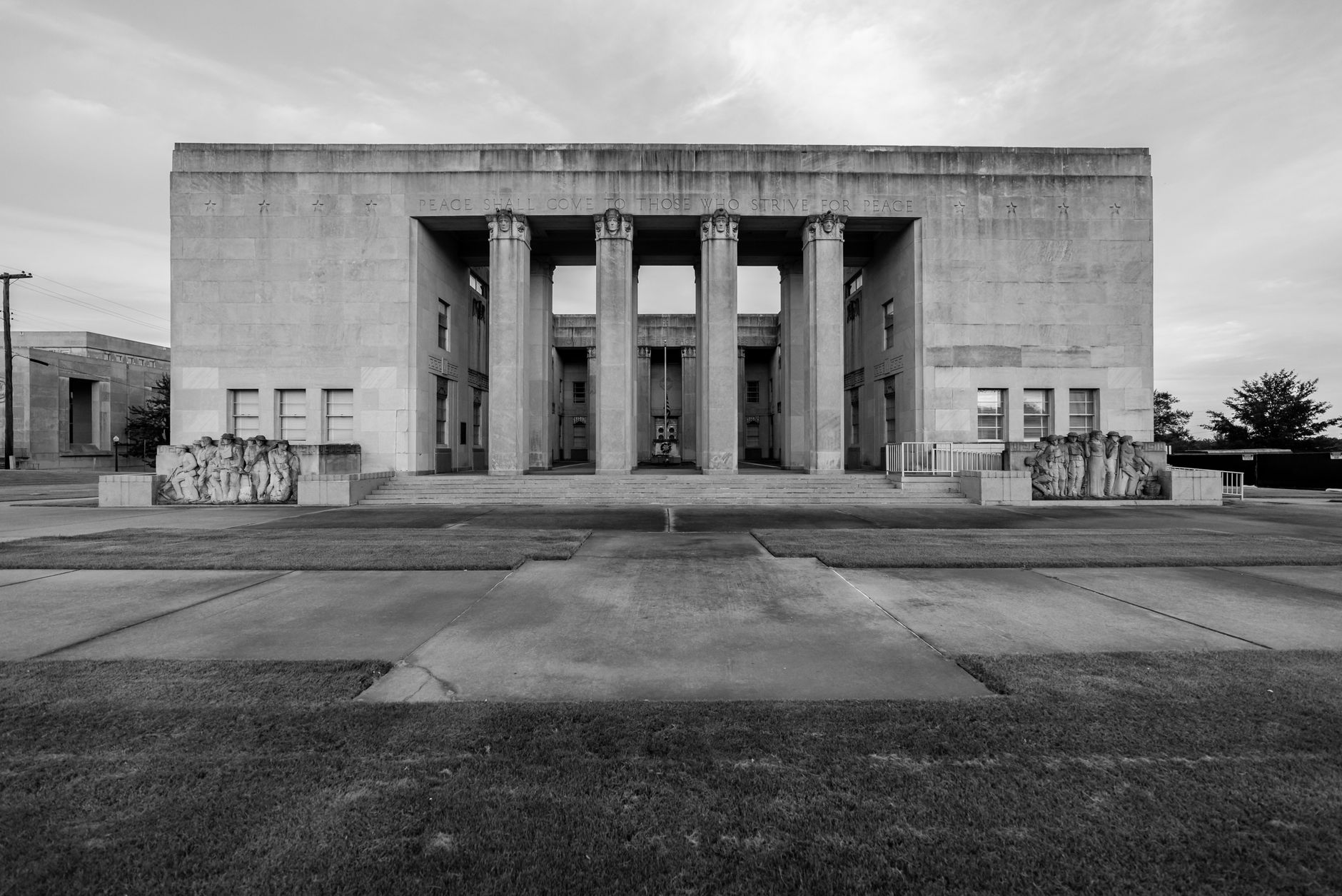 the exterior facade of a modern government courthouse building with tall stone columns and a wide concrete plaza