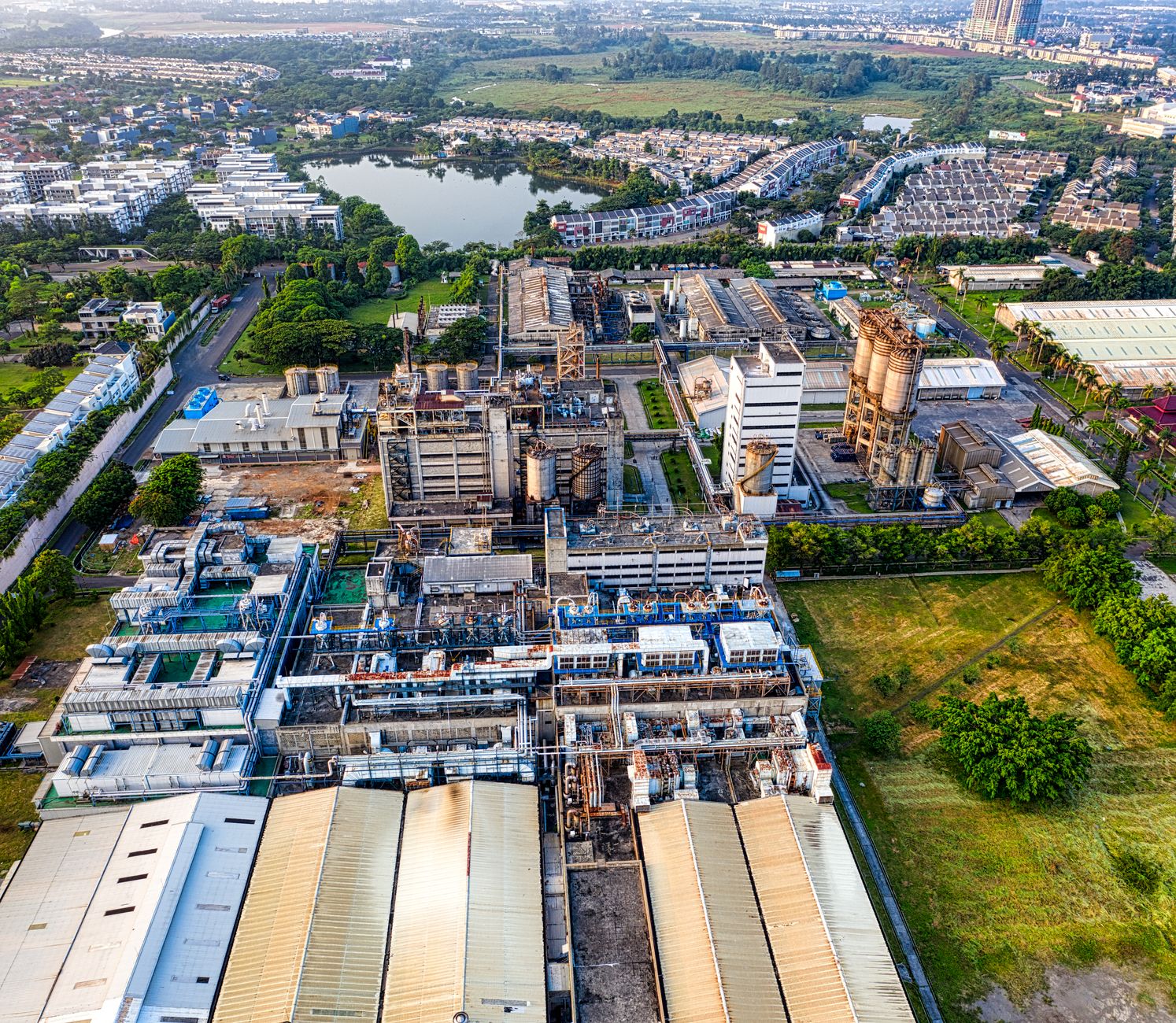 aerial view of a modern semiconductor fabrication facility surrounded by industrial infrastructure and access roads at dusk