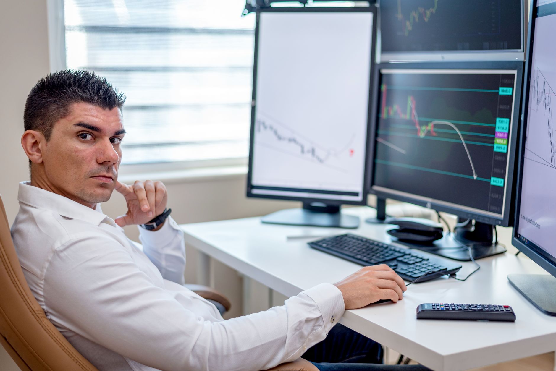 a wide-angle shot of multiple desktop monitors displaying real-time prediction market probability charts and trading interfaces in a dimly lit trading office