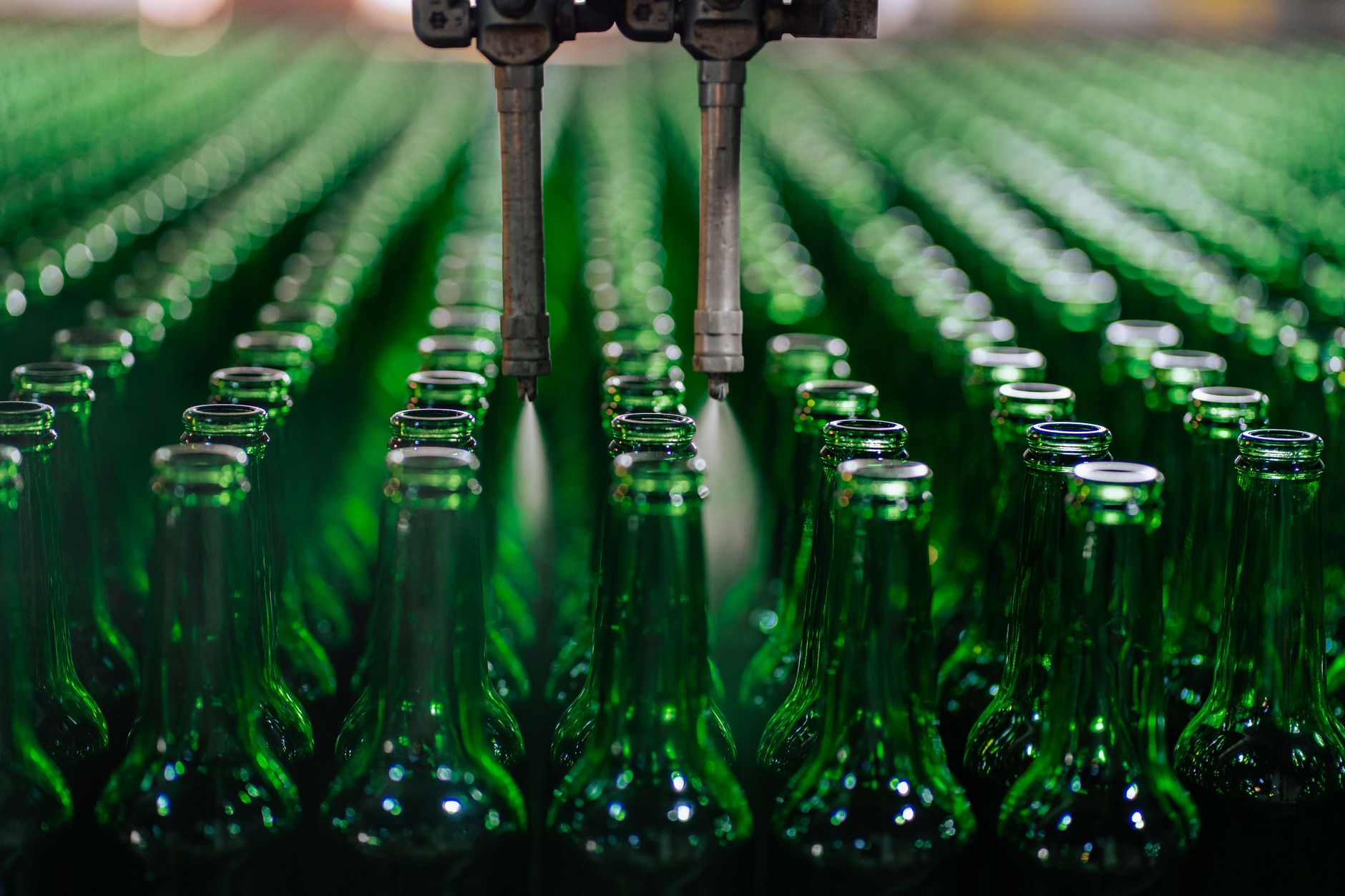rows of precision munition casings on a factory assembly line inside a well-lit industrial facility