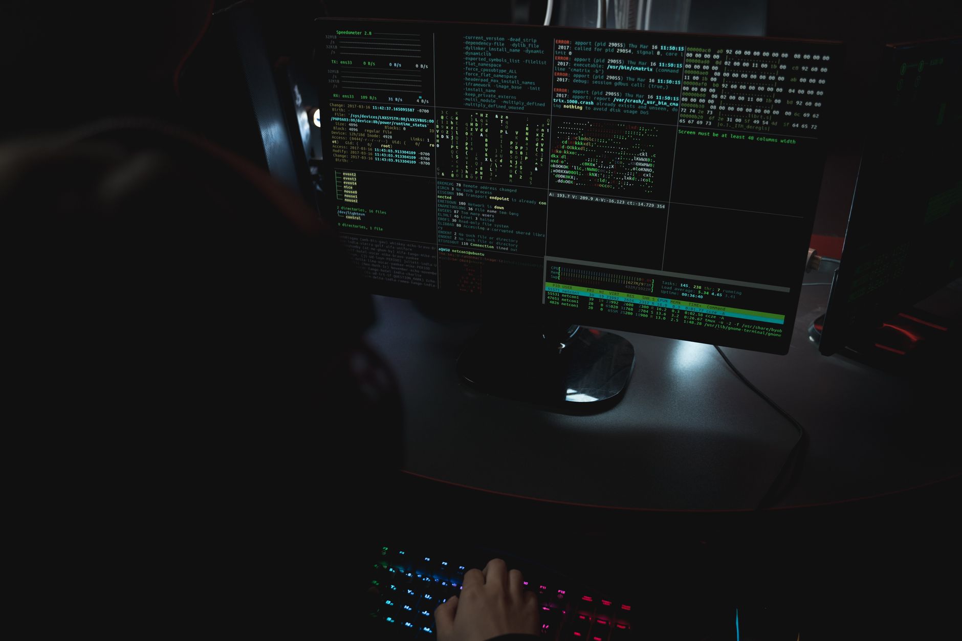 a cybersecurity operations center at night with rows of monitors displaying world maps overlaid with network connection lines and alert dashboards, workstations unmanned