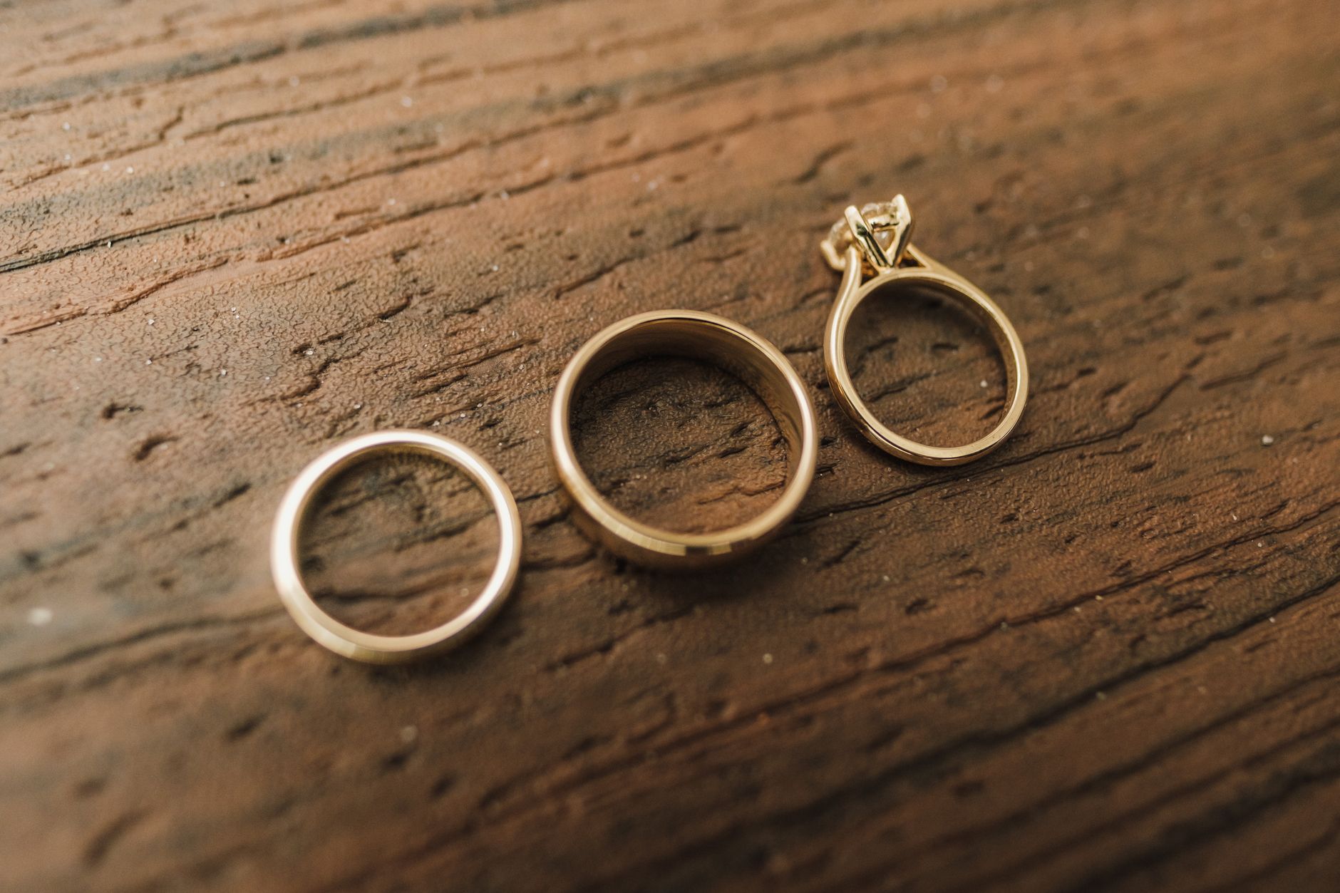 a close-up of multiple smart rings resting on a flat surface, showing different colors and band widths under soft studio lighting