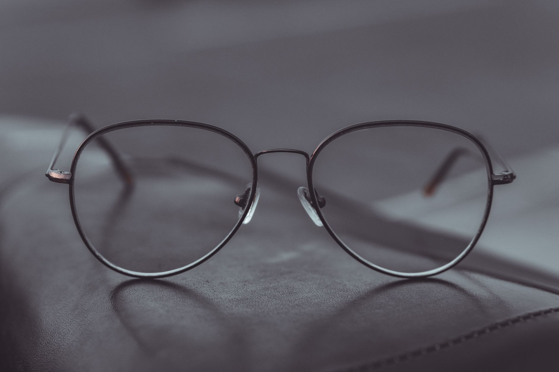 a close-up of a waveguide lens panel removed from an AR glasses frame, showing the internal light-guiding layer structure against a neutral gray background
