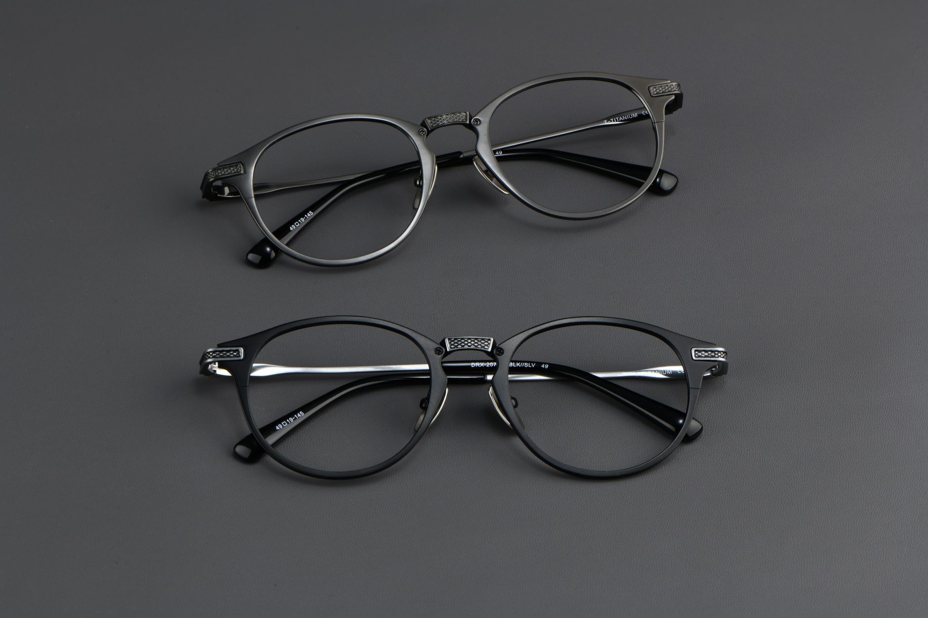 close-up of a pair of sleek AR smart glasses resting on a flat surface, showing waveguide lenses with a faint colorful tint, set against a neutral background