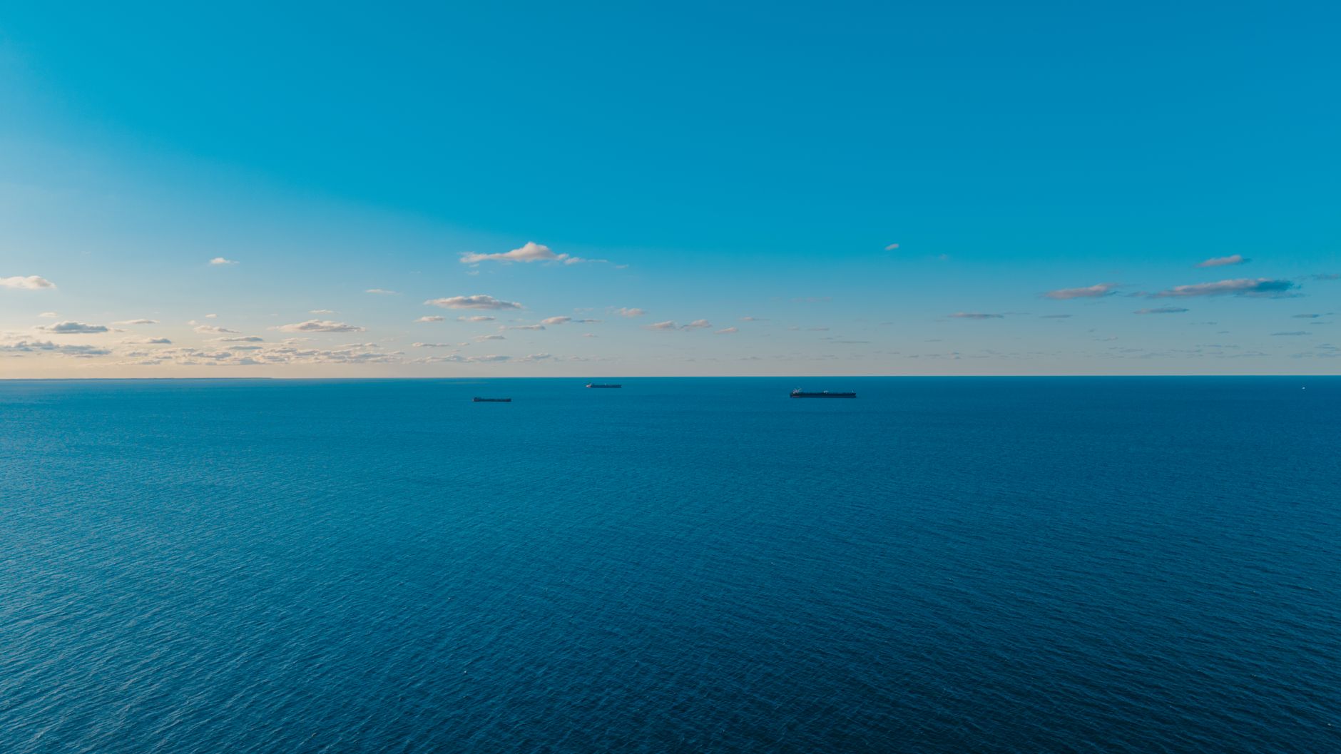 aerial view of a large product tanker vessel moving through open ocean waters under clear daylight
