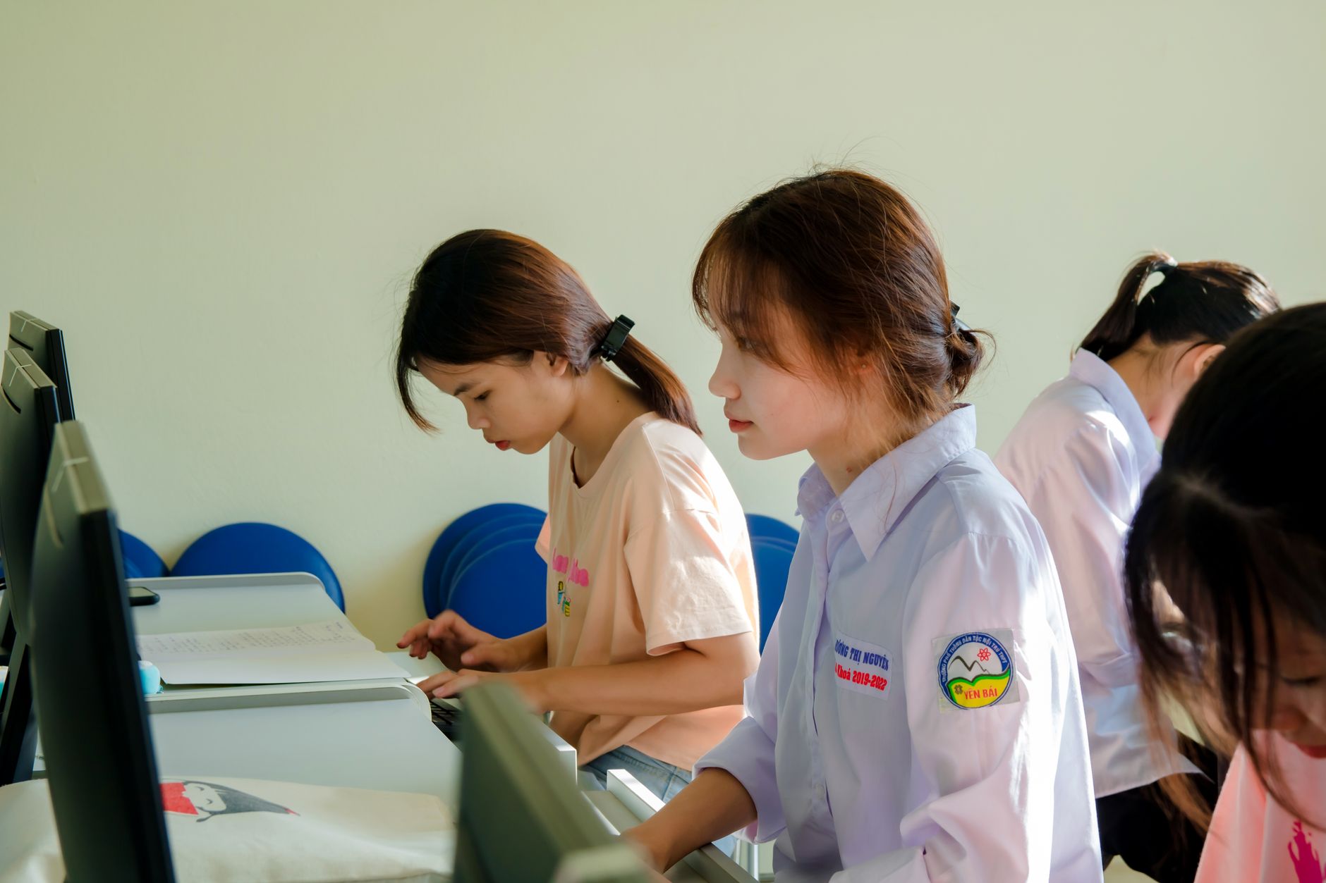 a school computer lab with student workstations displaying colorful goal-setting and career-exploration interfaces on screen, natural light coming through windows