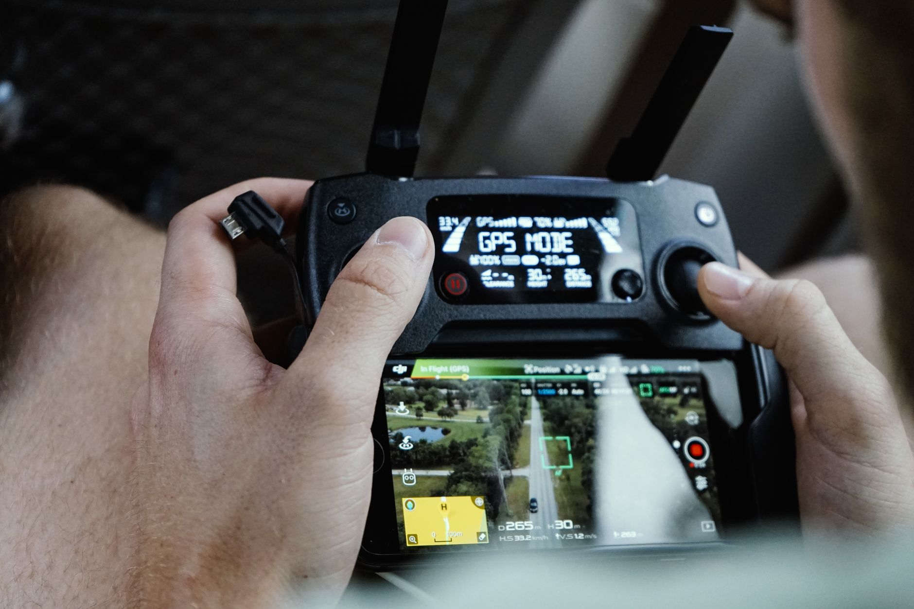 a wide-angle view of a drone command-and-control station interior, multiple screens displaying aerial feed and navigation overlays, no operators in foreground