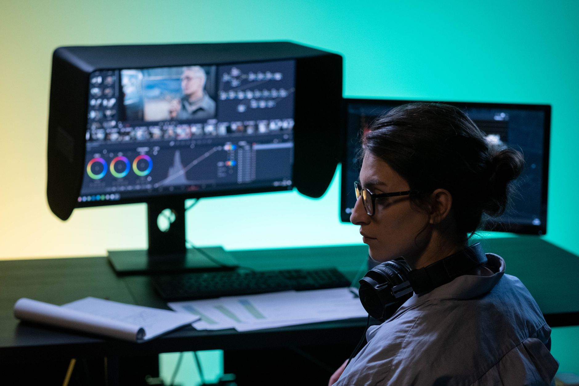a wide-angle view of a professional video editing workstation with multiple monitors displaying timeline software and AI-generated caption overlays, shot in a modern studio environment