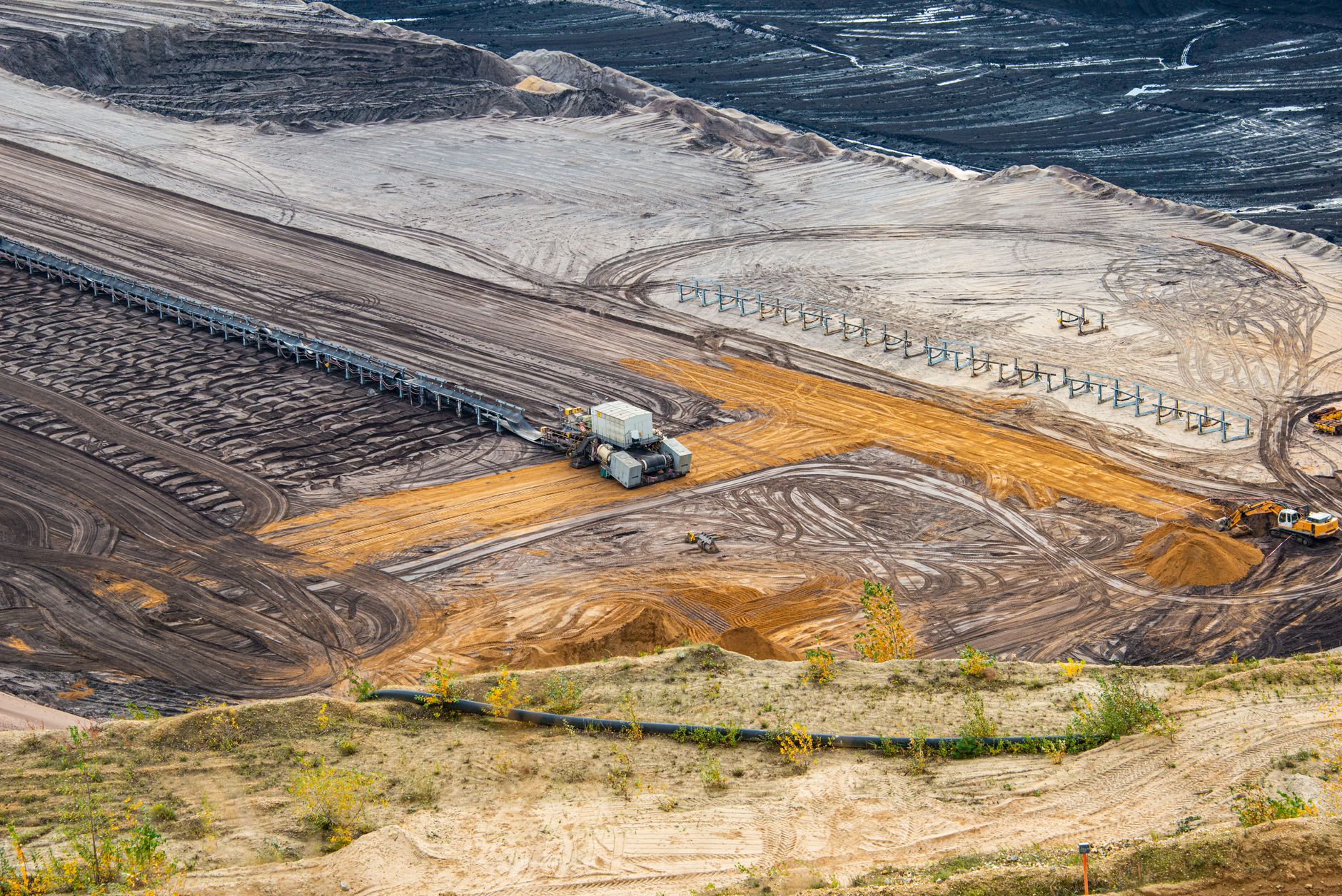 Wide aerial view of a large, rust-colored artificial tailings lake surrounded by industrial processing facilities and arid Inner Mongolian landscape