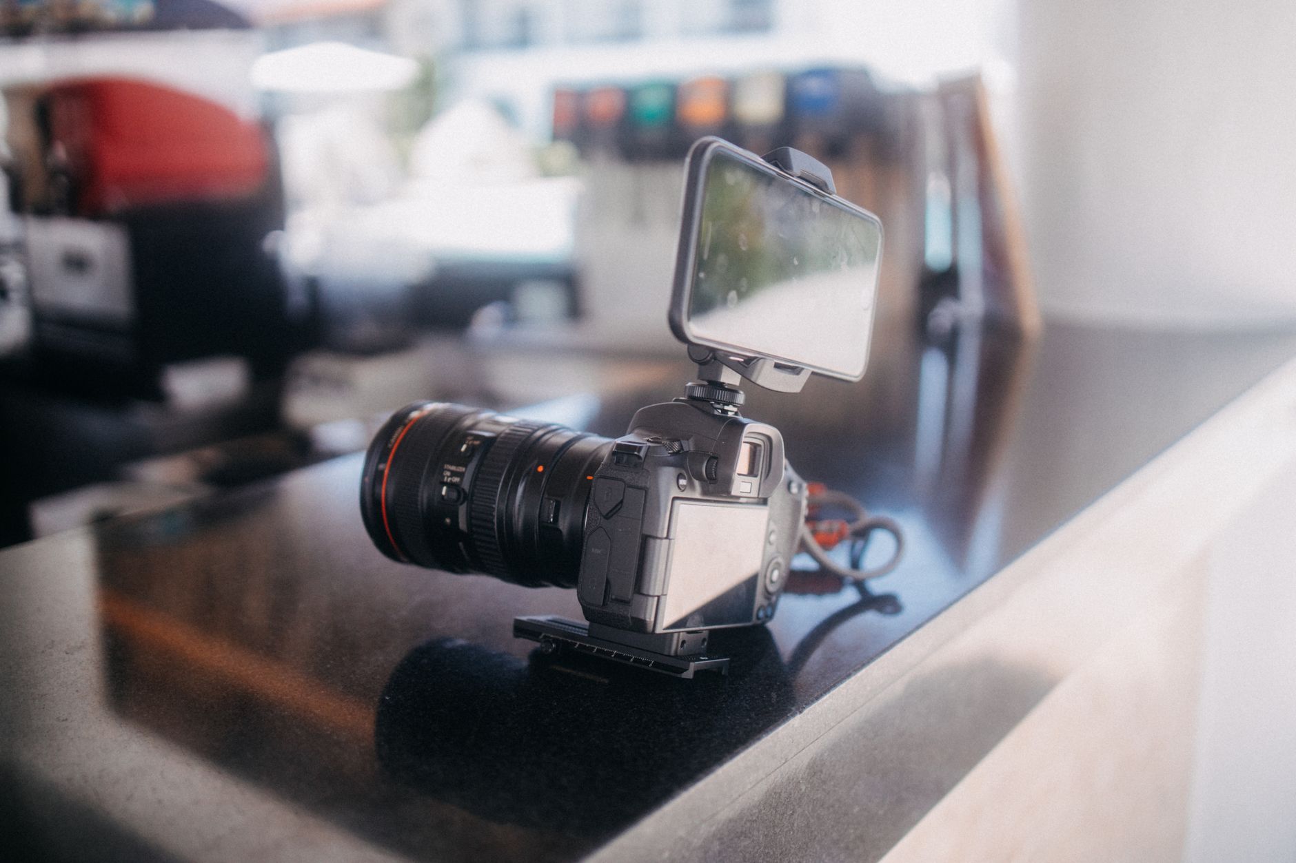 a smartphone propped against a kitchen backsplash displaying a pet video on a social media feed, soft focus background showing a tiled countertop